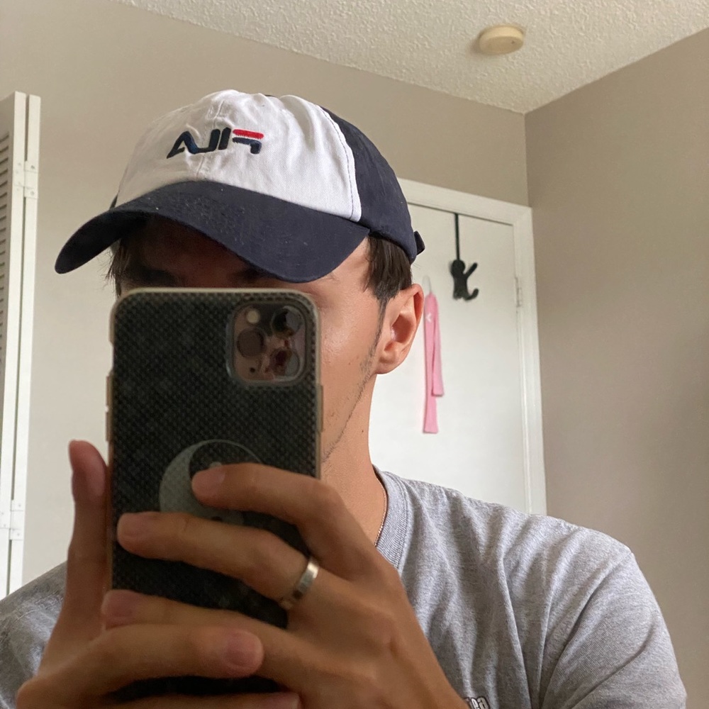White, blue, and red FILA baseball hat.